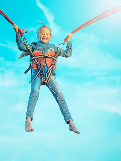 istock Girl in denim soars upward bound straps. 871053374