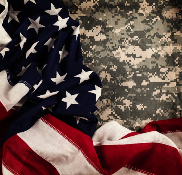 istock American flag with US military uniform 871053734