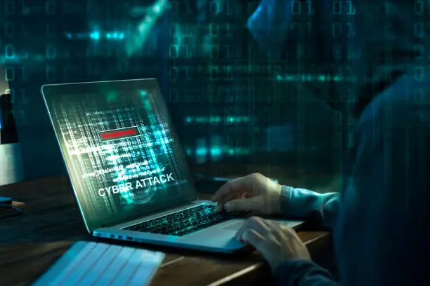 Photo of Computer hacker. Internet crime working on a code on laptop screen with dark digital background. Cyber attack in cyberspace concept