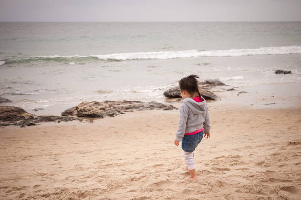 istock Little girl walking on beach at Crystal Cove, CA 871070762