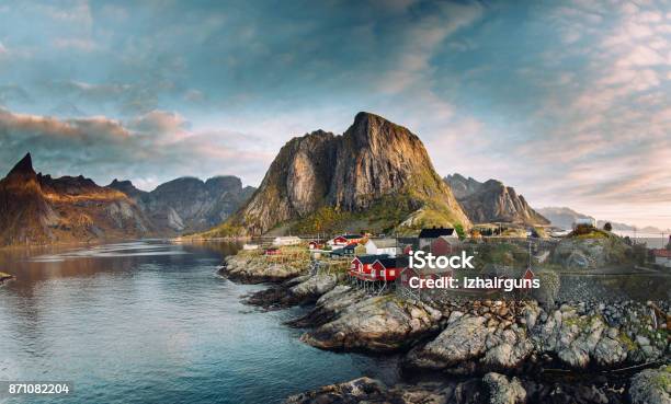Norwegian Fishing Village At The Lofoten Islands In Norway Dramatic Sunset Clouds Moving Over Steep Mountain Peaks Stock Photo - Download Image Now