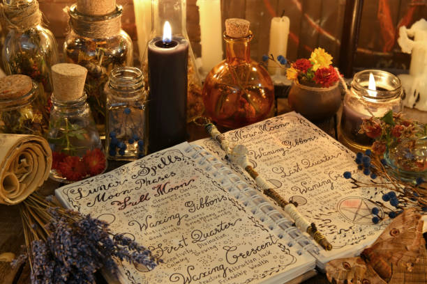 livre de magie avec des sorts, bouquet de lavande et bougie noire - wicca photos et images de collection