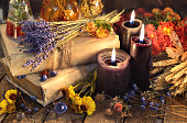 Three black candles, lavender bunch, healing herbs and flowers