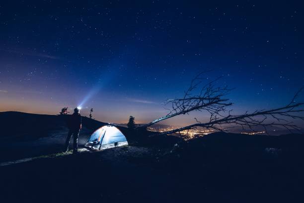 istock Man pointing light from his flashlight to the sky. 871090022
