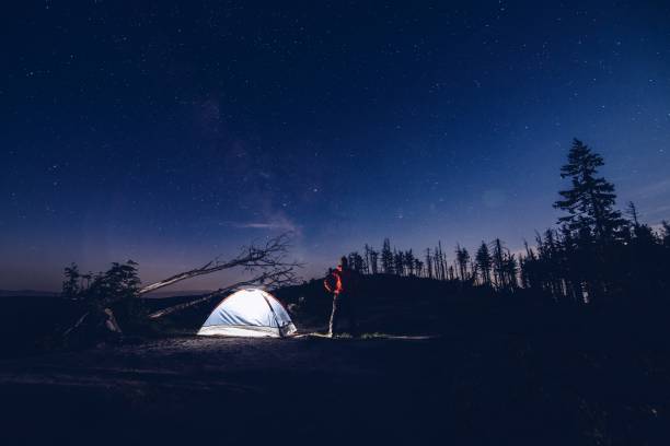 istock Man tourist at night camp in mountains. 871090084