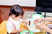 母と小さな女の子のハロウィーン パーティーのためのクッキーにアイシングを適用します。