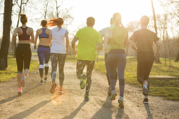istock Rear view of people jogging on dirt road 871091420