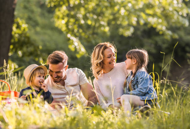 jovem feliz família desfrutando no piquenique durante a primavera na floresta. - family with two children family park child - fotografias e filmes do acervo