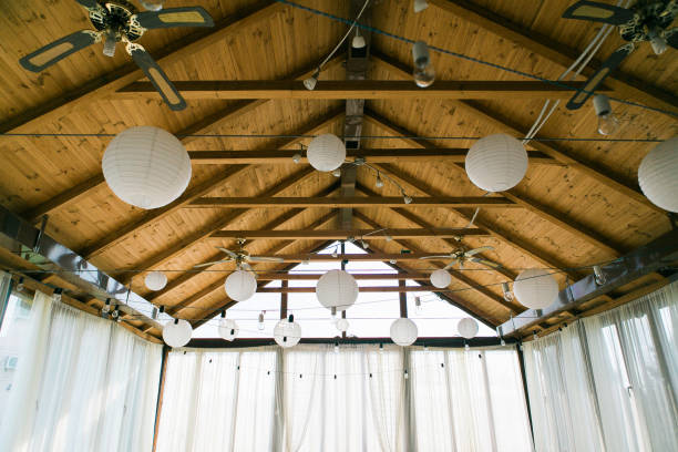 istock Decorated tent with bulb garland. Wedding setup white paper lanterns inside of building, under wooden roof decoration. 871102006