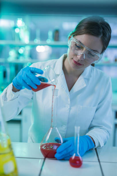 istock Young female scientist mixing toxic substances in laboratory. 871102248