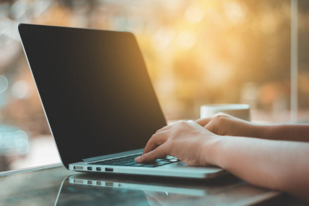 istock Hands typing on laptop in coffee shop 871105040