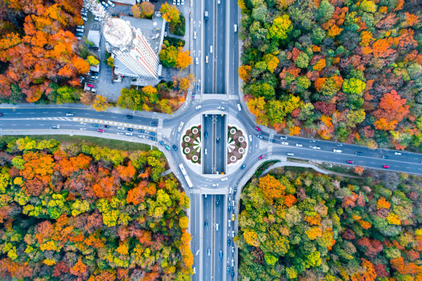 Aerial eagle eye view of a traffic circle roundabout located between beautiful autumn forest