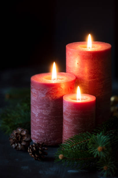istock Three Christmas candles with pine cones and fir branches 871112454