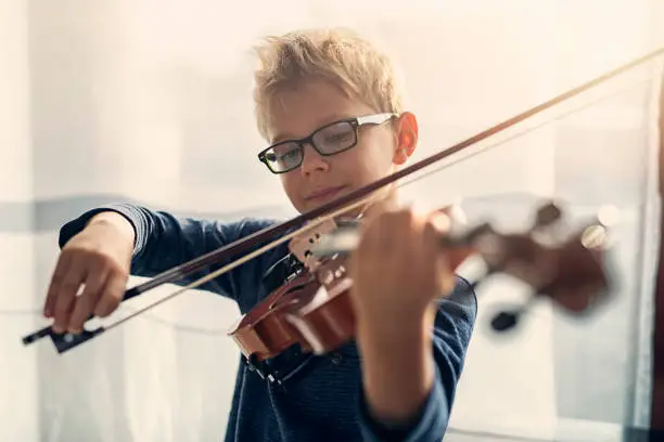 Photo of Little boy practicing violin