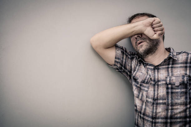 istock portrait one sad man standing near a wall and covers his face 871112930