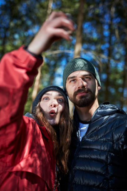 istock Young couple relaxing in the forest. Making selfie 871113986