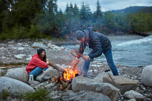 istock Young couple making a bonfire. Mountainous landscape 871117486
