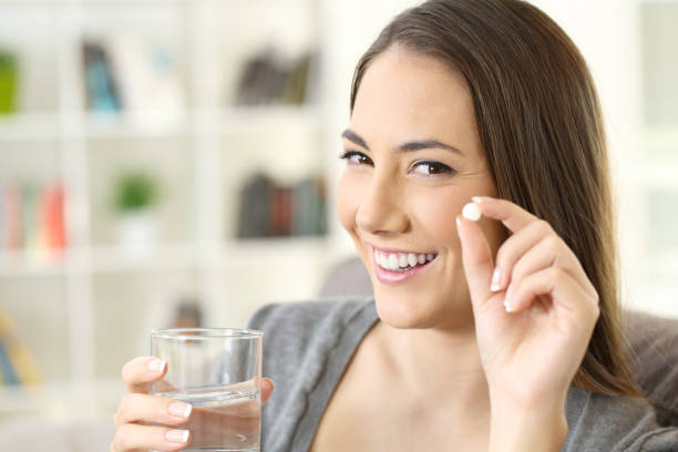 istock Woman holding a pill looking at camera 871125556