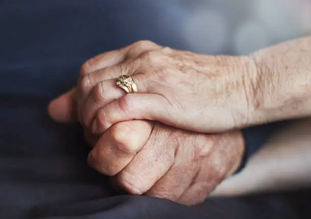 Photo of Senior married couple's hands, tightly clasped together