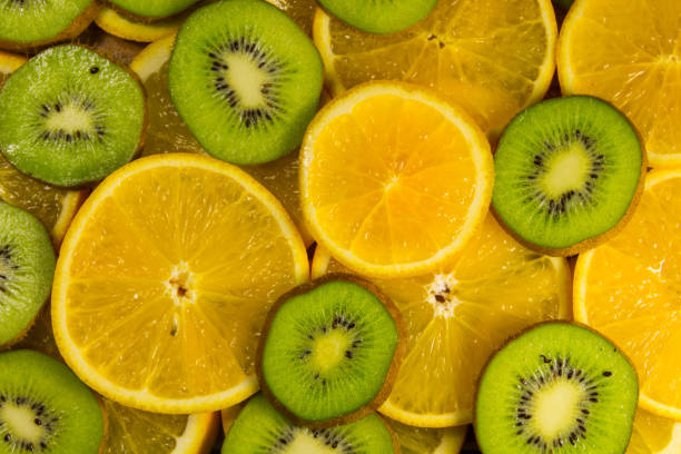 istock Sliced kiwi fruits and oranges for background 871125950