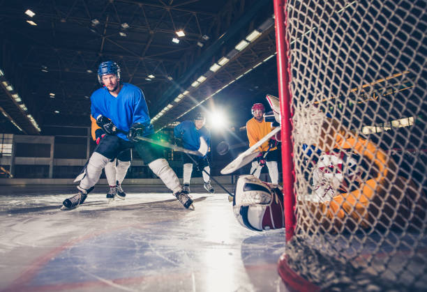 istock Young ice hockey player taking a shot during the game at rink. 871129152