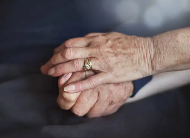 Photo of Elderly married couple's hands; she pats his reassuringly