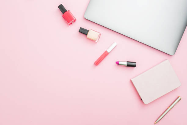 istock Home workspace desk with laptop, notebook and cosmetics on pink background. Top view. Flat lay lifestyle concept. 871130058