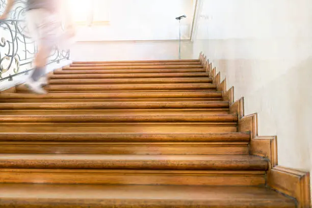 Photo of motion blur, man goes upstairs, old wooden stairs