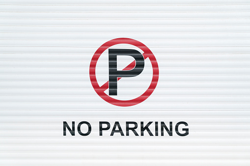 no parking sign on a withe roller shutter