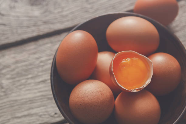 istock Fresh brown eggs in bowl on wood background 871157262
