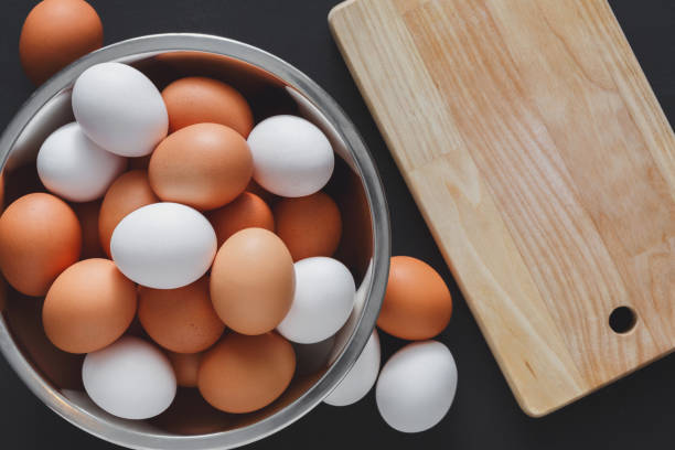 istock Fresh brown eggs in bowl isolated on black background 871161130