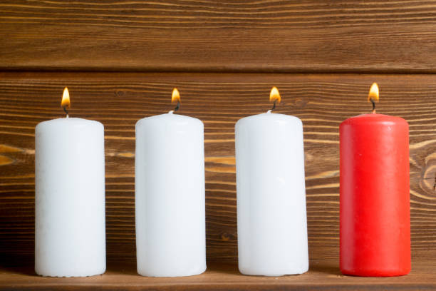istock four candles with wooden rustic planks background 871165560