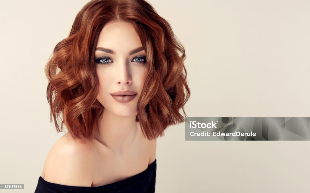 Attractive brown haired  woman  with modern, trendy and elegant hairstyle. Attractive brown haired  woman  with modern, trendy and elegant hairstyle. Example of middle length,dense and curly hair.Gentle make up and long eyelashes. Hairstyle Stock Photo