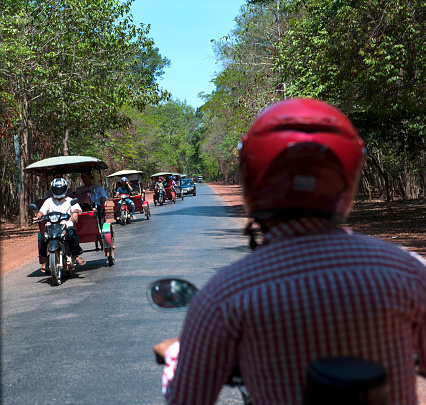 Siem Reap, Cambodia - May 18, 2016: A lot of tricycle drivers carrying some tourists around Angkor Wat, Siem Reap, Cambodia.