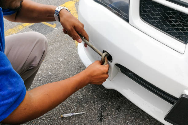 istock Mechanic fixing hook and chain onto car to tow 871167910