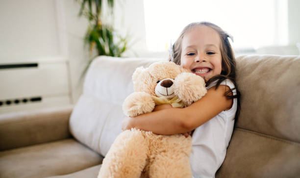 istock Cute little girl playing with teddy bear 871168852