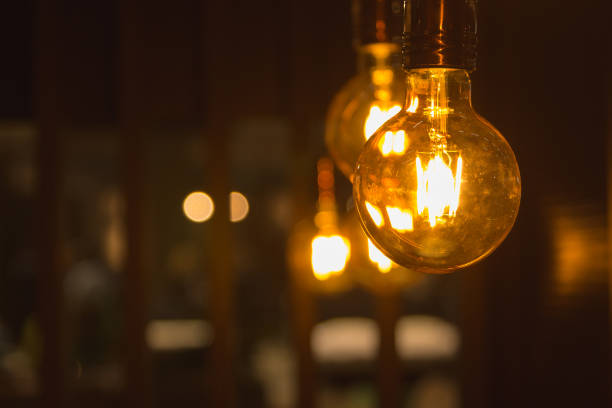 istock A glowing light bulbs. Light bulbs on a dark background with copy space. 871173198