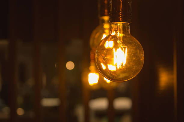 istock A glowing light bulbs. Light bulbs on a dark background with copy space. 871173388