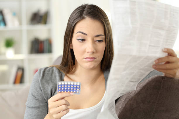 istock Suspicious woman reading a leaflet after taking contraceptive pills 871176754