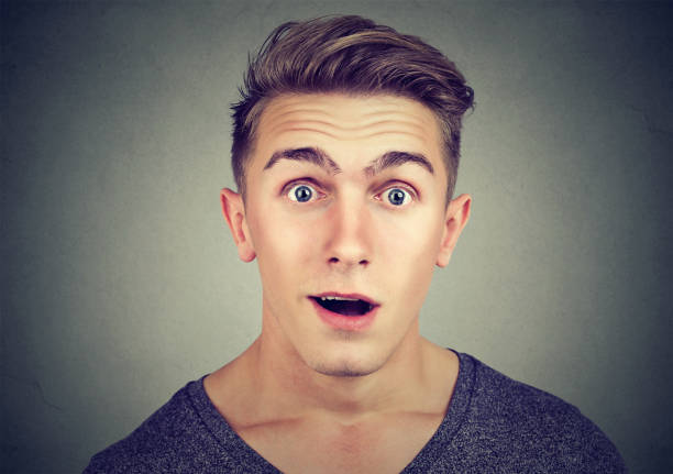 portrait of a surprised young man looking at camera