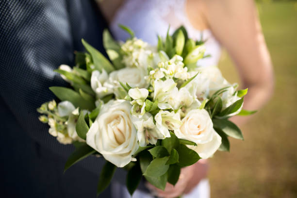 istock Big nice wedding bouquet in woman's hands. Bride and groom on their wedding hugging 871179568