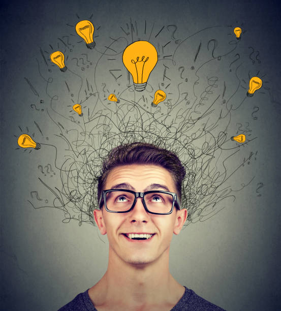 istock Excited man looking up at many ideas light bulbs above head isolated on gray wall background. Eureka concept 871179888