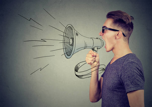 istock Young man screaming into a megaphone making an announcement 871179956