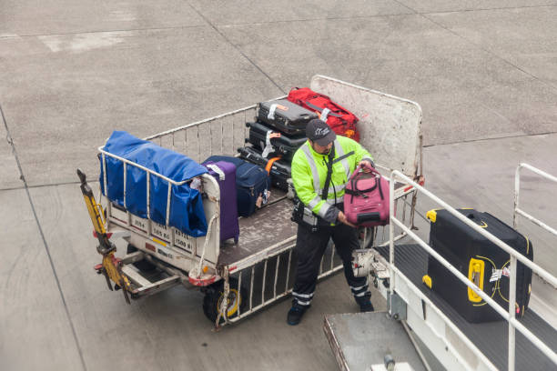 Frankfurt, Germany - Oct 10, 2017: Luggage being loaded from the trolley to belt conveyor and into the aircraft