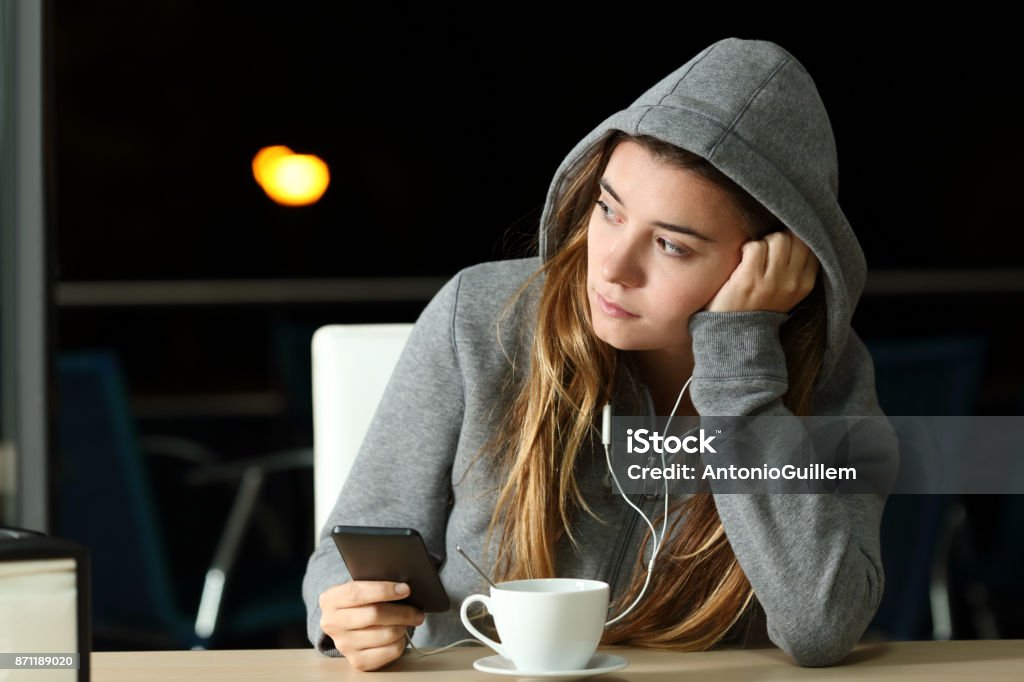 Triste adolescente escuchando música en un bar - Foto de stock de Adolescente libre de derechos