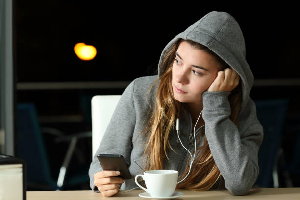 triste adolescente escuchando música en un bar - one teenage fotografías e imágenes de stock