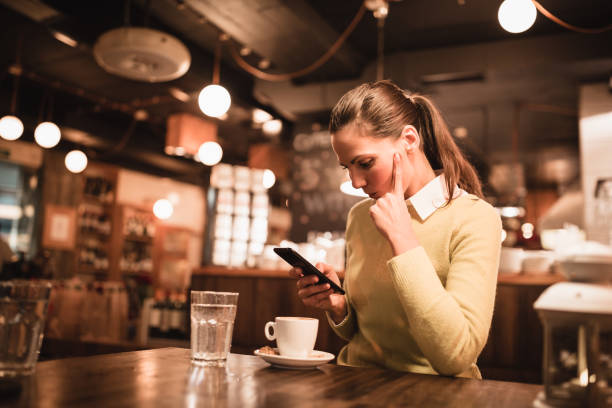 istock Single. Young woman enjoying coffee and using a smart phone in cafe 871189302