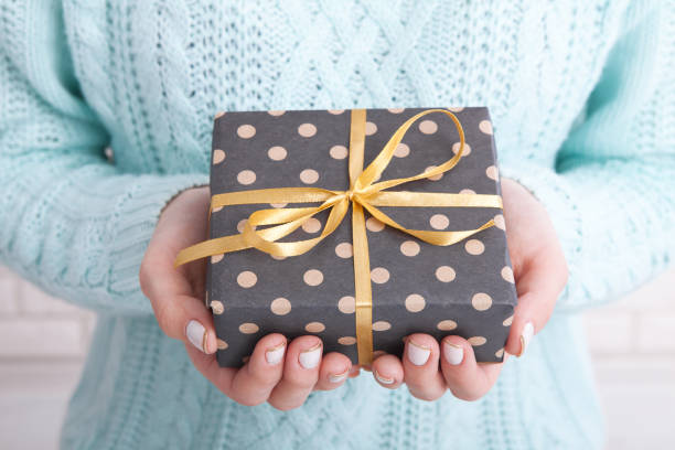istock Gift box with ribbon in women's hands. 871189660