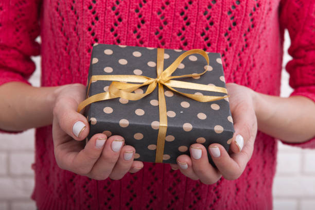istock Gift box with ribbon in women's hands. 871189674