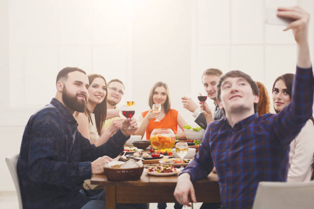 istock Group of happy people take selfie at festive table dinner party 871189706